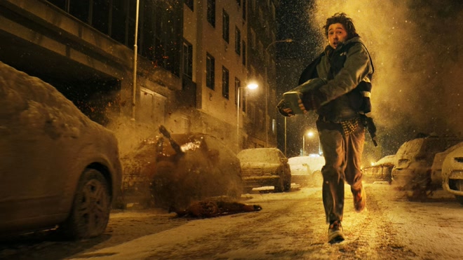 電影截圖。人物跑過一條積雪的街道。