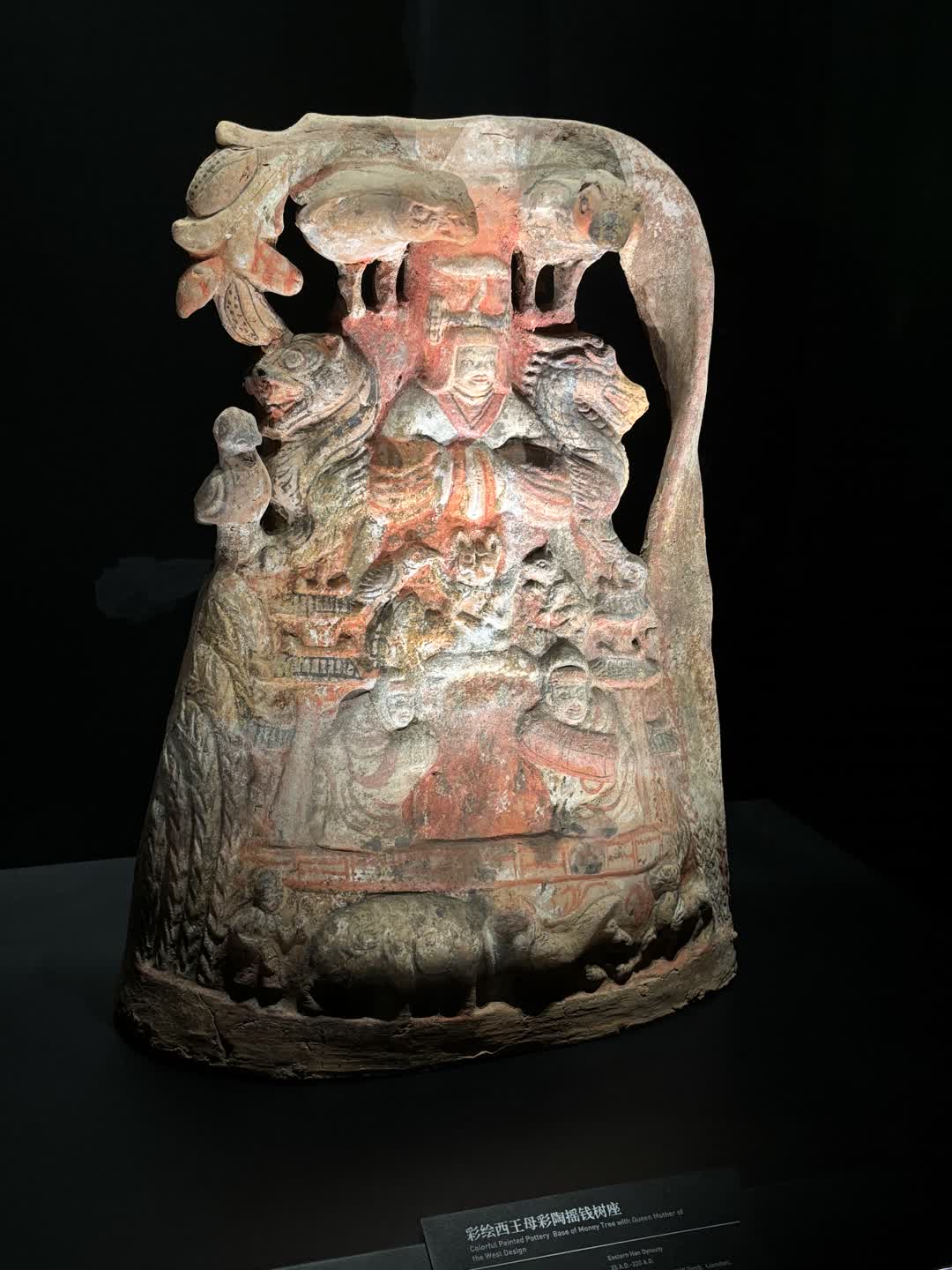 彩繪陶器。色彩以紅棕、橙、米黃為主。中心為戴冠坐於果樹下的西王母,雙肩上方左右各有一鳥。兩側各有一隻似龍似虎的獸,左獸向左,右獸向右。底部繪有人物和動物。